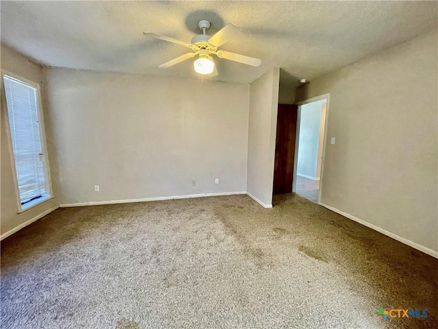 unfurnished room with carpet floors, ceiling fan, a textured ceiling, and baseboards