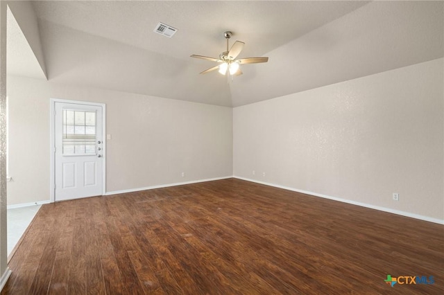 empty room featuring baseboards, visible vents, dark wood finished floors, a ceiling fan, and lofted ceiling