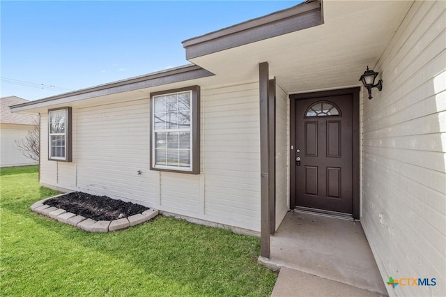 doorway to property with a yard