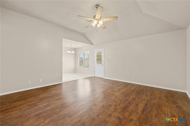 spare room featuring ceiling fan with notable chandelier, vaulted ceiling, baseboards, and wood finished floors