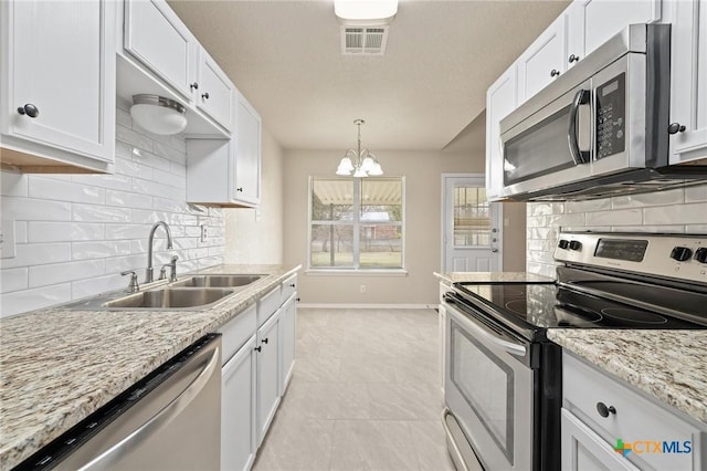 kitchen featuring stainless steel appliances, a sink, visible vents, and white cabinetry