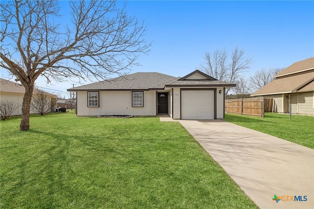 view of front of home with an attached garage, driveway, fence, and a front lawn