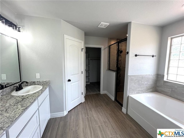 3827 Leming Ct, Temple, TX 76504 - bathroom with vanity, a shower stall, a garden tub, a walk in closet, and baseboards
