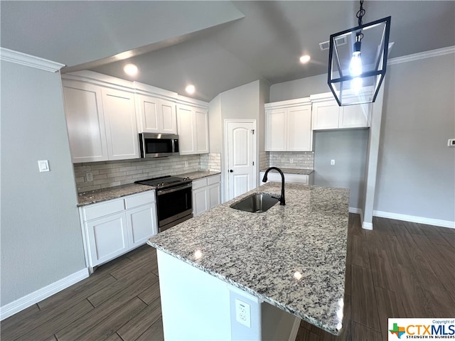 kitchen featuring stainless steel appliances, white cabinets, sink, and an island with sink