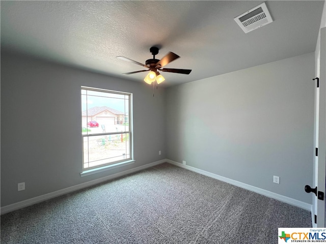 carpeted empty room featuring ceiling fan and a textured ceiling