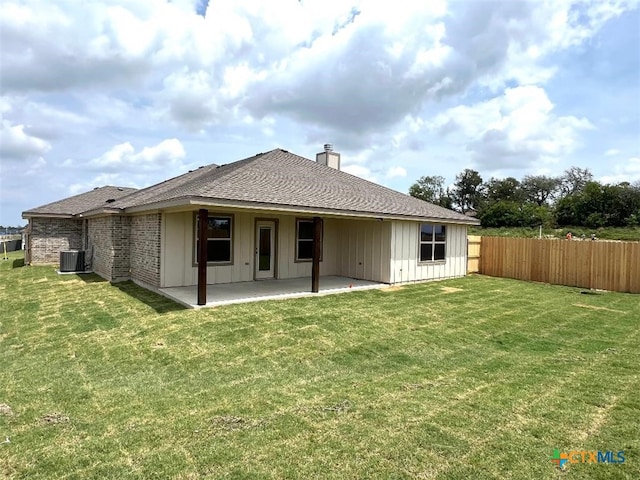 rear view of house with cooling unit, a yard, and a patio area