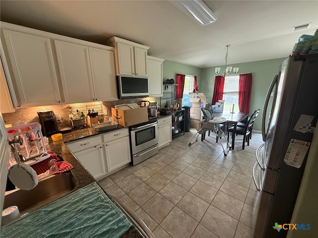 5629 Stonehaven Dr, Temple, TX 76502 - kitchen with stainless steel appliances, dark countertops, and white cabinetry
