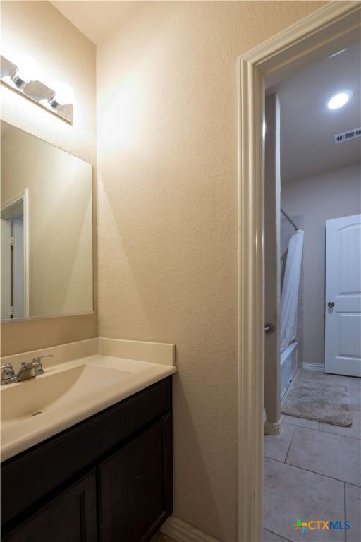 full bathroom with vanity, shower / tub combo, and tile patterned floors