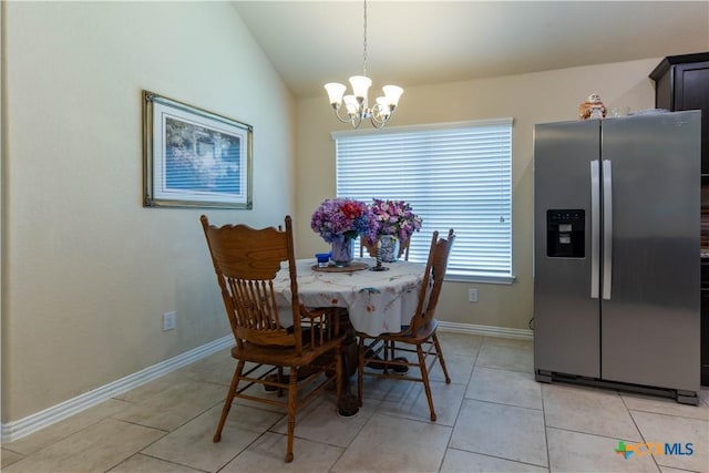 dining room featuring a chandelier, vaulted ceiling, light tile patterned floors, and baseboards