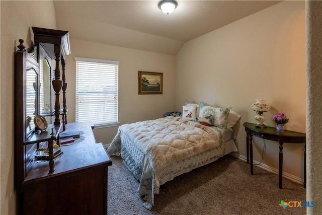 carpeted bedroom with baseboards and lofted ceiling