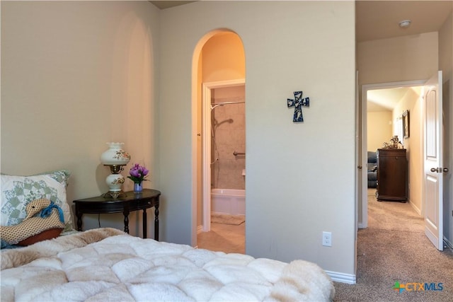 bedroom with arched walkways, carpet floors, and baseboards