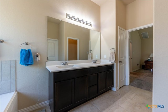 bathroom with double vanity, tile patterned flooring, and baseboards