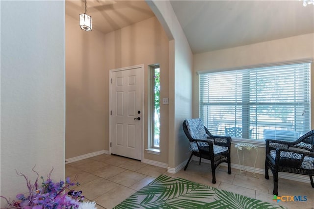 entrance foyer with arched walkways, tile patterned flooring, and baseboards
