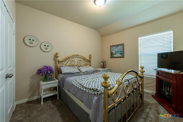 carpeted bedroom featuring vaulted ceiling and baseboards