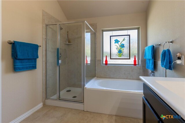 bathroom with a shower stall, a garden tub, tile patterned flooring, and vanity