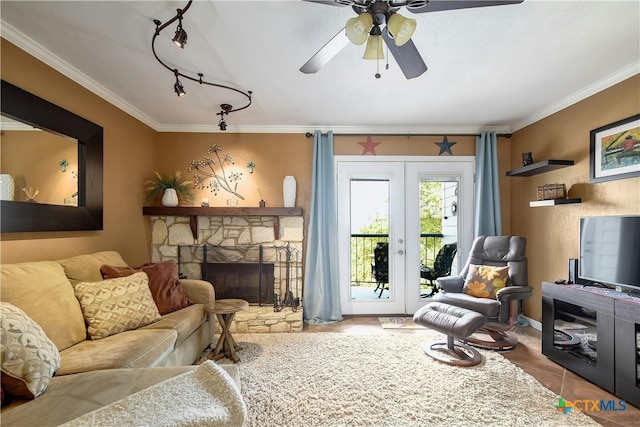 living room with french doors, tile patterned floors, crown molding, a fireplace, and ceiling fan