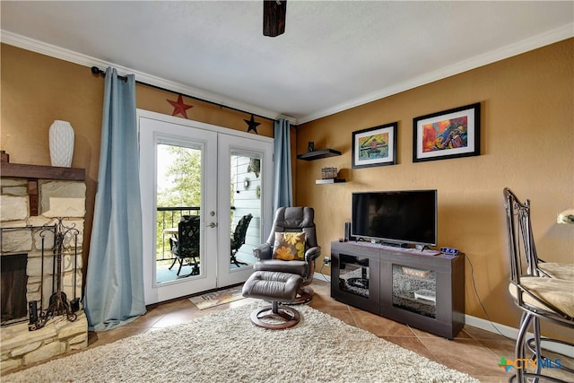 sitting room with a stone fireplace, french doors, light tile patterned floors, and crown molding