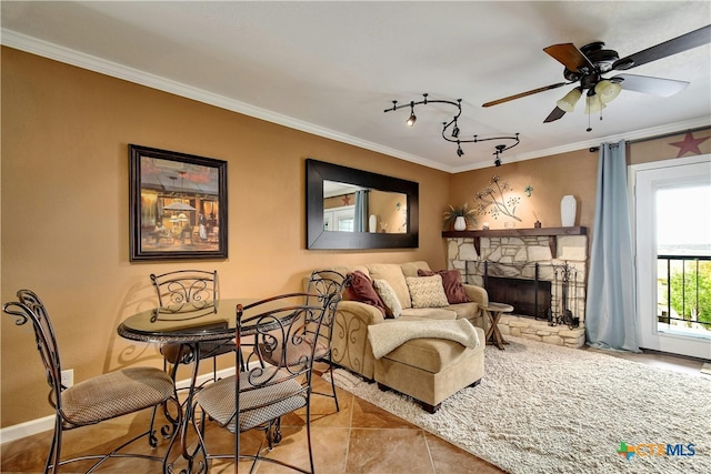 tiled living room with a stone fireplace, ceiling fan, and crown molding