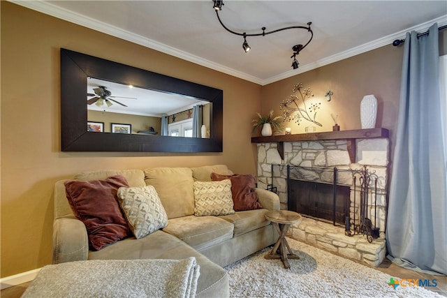 living room featuring ceiling fan, a stone fireplace, and ornamental molding