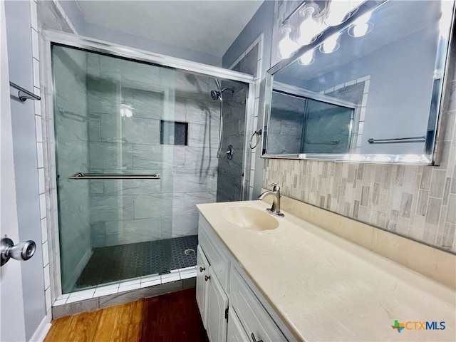 bathroom featuring walk in shower, vanity, and hardwood / wood-style floors