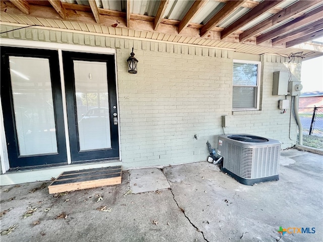 property entrance featuring central air condition unit and a patio