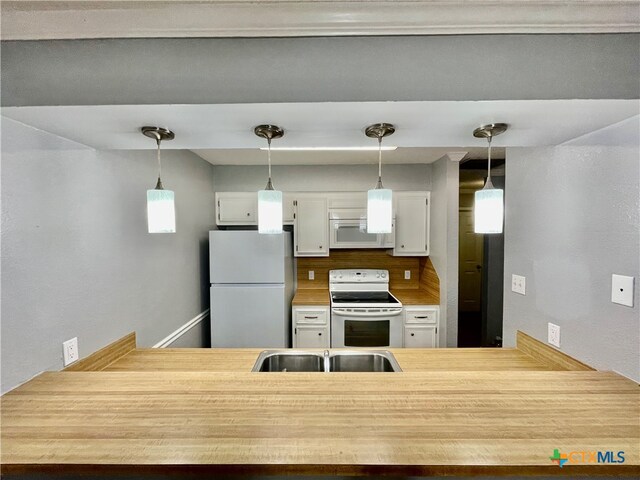 kitchen featuring white cabinets, white appliances, sink, and a wealth of natural light