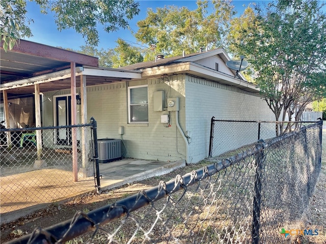 view of side of property with central AC unit and a patio