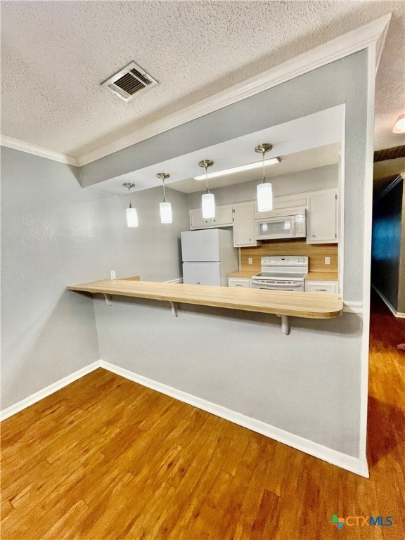 kitchen featuring kitchen peninsula, white appliances, hardwood / wood-style floors, and white cabinets