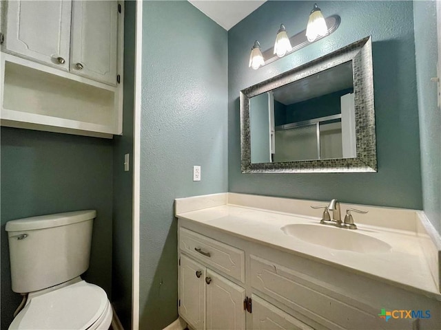 409 Versailles St, Victoria, TX 77904 - full bath featuring toilet, vanity, a shower with door, and a textured wall