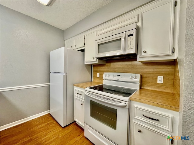 kitchen featuring white cabinetry, light wood-type flooring, white appliances, and a textured ceiling