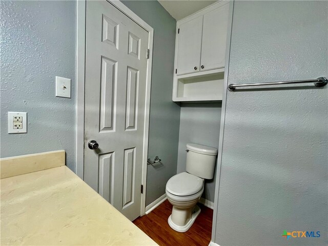 bathroom with toilet and wood-type flooring