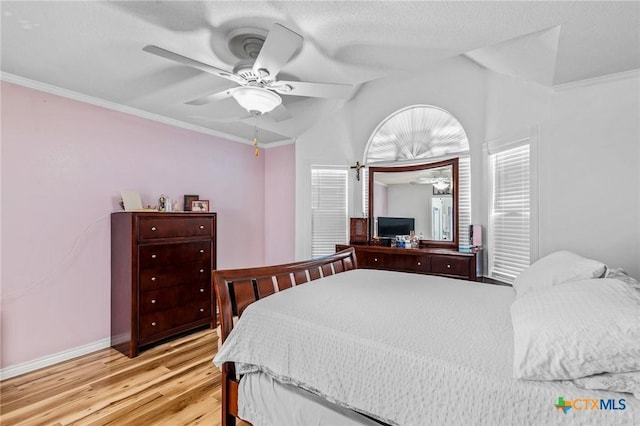 bedroom featuring baseboards, vaulted ceiling, crown molding, ceiling fan, and light wood finished floors