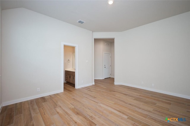 spare room featuring visible vents, light wood finished floors, and baseboards