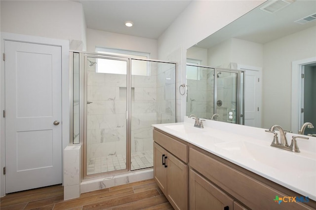 full bath featuring a shower stall, a sink, and visible vents