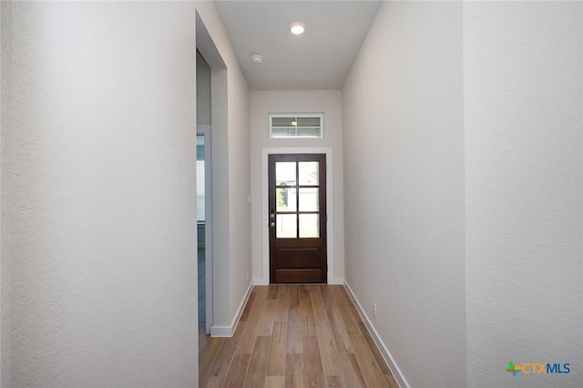 doorway featuring baseboards, wood finished floors, and recessed lighting