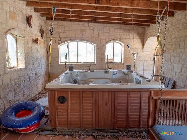 full bathroom featuring a jetted tub and a healthy amount of sunlight