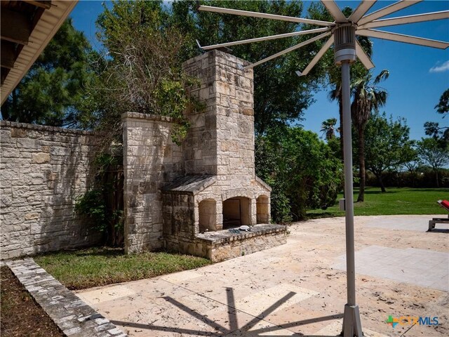 view of patio featuring an outdoor stone fireplace
