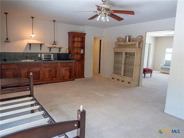living area with light carpet, a toaster, and a ceiling fan