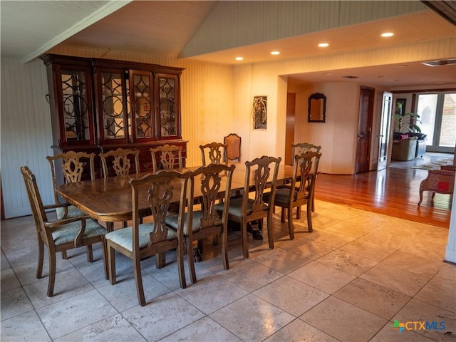 dining space featuring wooden walls and visible vents
