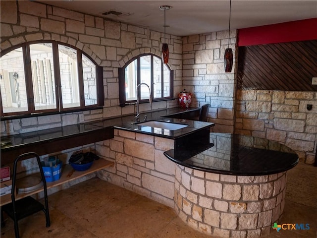 kitchen with a sink, visible vents, and dark countertops