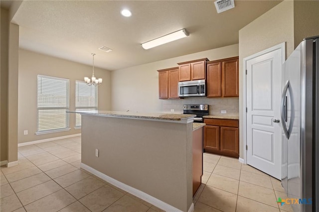 kitchen featuring light tile patterned floors, visible vents, brown cabinets, and appliances with stainless steel finishes