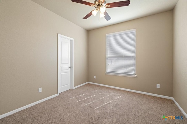 spare room with baseboards, ceiling fan, and carpet flooring