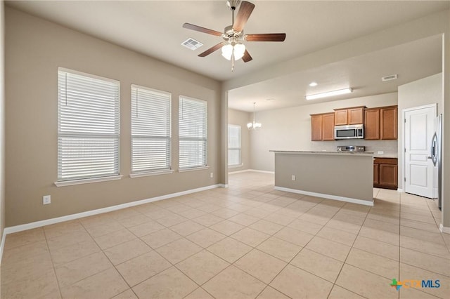 kitchen with visible vents, baseboards, open floor plan, ceiling fan with notable chandelier, and appliances with stainless steel finishes