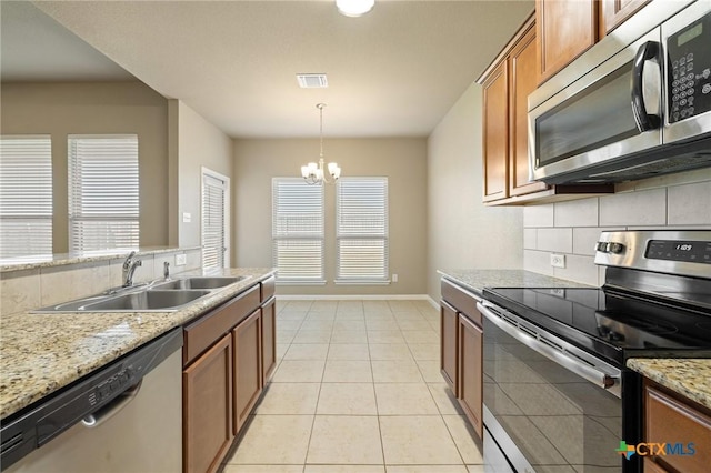 kitchen with brown cabinets, visible vents, appliances with stainless steel finishes, and a sink