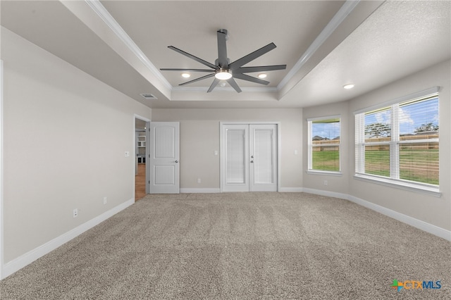 unfurnished bedroom with carpet flooring, a tray ceiling, ceiling fan, and crown molding