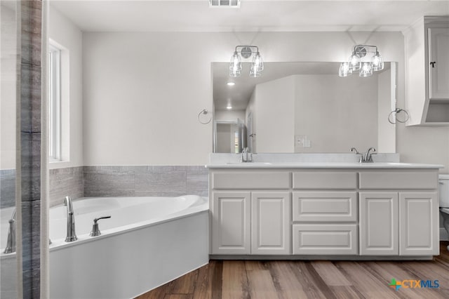 bathroom with a bath, wood-type flooring, vanity, and toilet