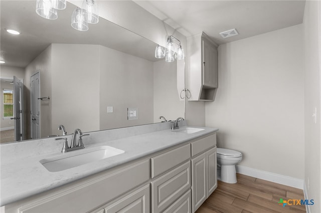 bathroom featuring hardwood / wood-style floors, vanity, and toilet