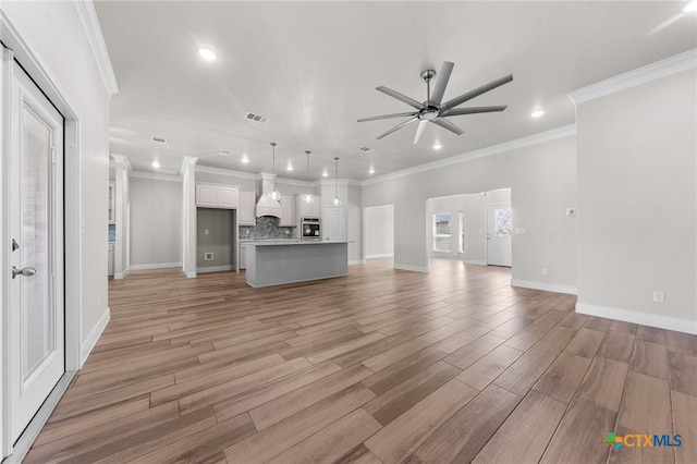 unfurnished living room with ceiling fan, crown molding, and light wood-type flooring