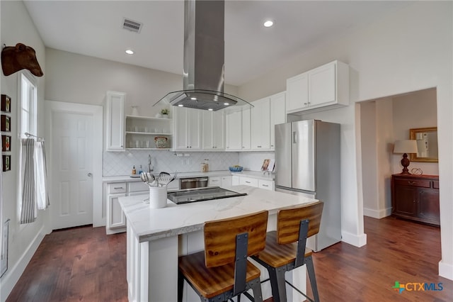 kitchen with island range hood, appliances with stainless steel finishes, white cabinets, dark wood-type flooring, and a center island