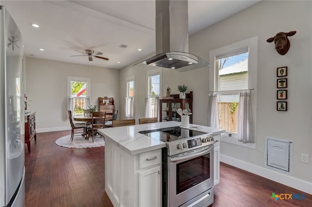 kitchen featuring white cabinetry, stainless steel electric range oven, a healthy amount of sunlight, and island exhaust hood